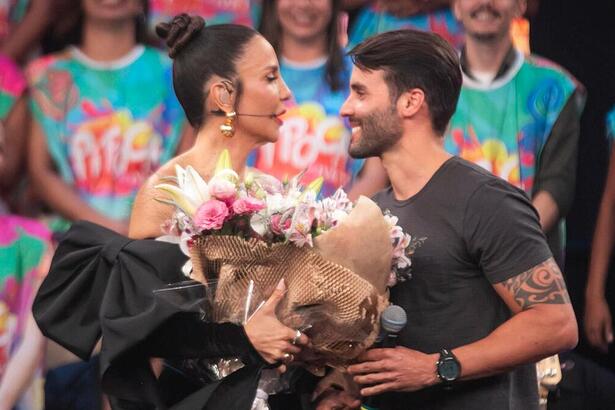 Ivete Sangalo, com um buquê de flores, ao lado de Daniel Cady no palco do Pipoca