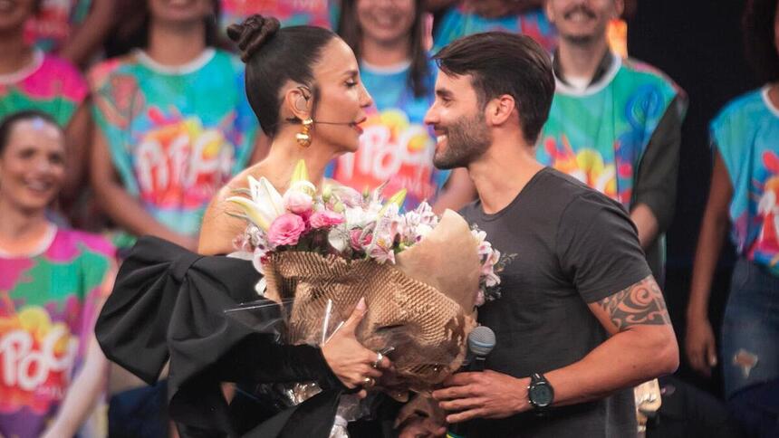 Ivete Sangalo, com um buquê de flores, ao lado de Daniel Cady no palco do Pipoca