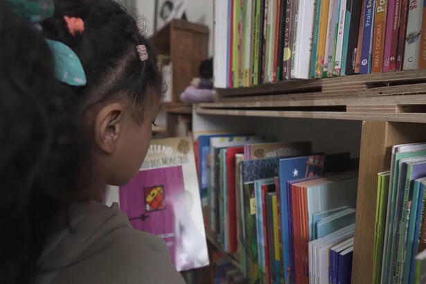 Menina em uma biblioteca, em trecho do Globo Repórter