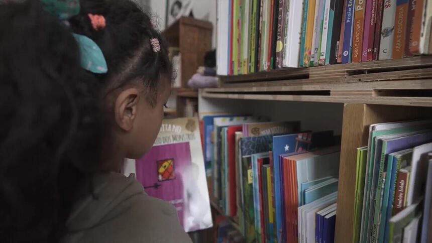 Menina em uma biblioteca, em trecho do Globo Repórter