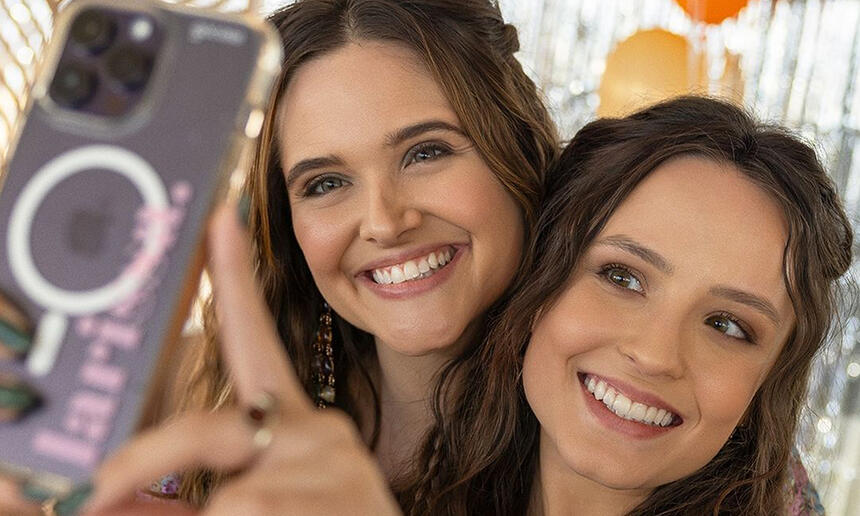 Juliana Paiva e Larissa Manoela sorrindo, fazendo selfie, durante gravação de série da Netflix