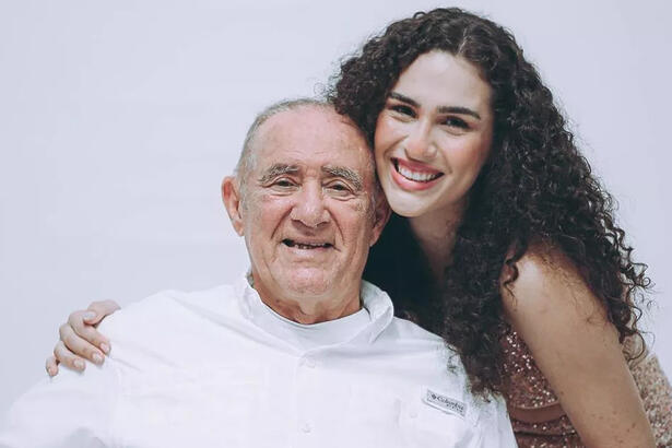 Lívian Aragão sorrindo, de cabelo solto, sorrindo, abraçada com Renato Aragão