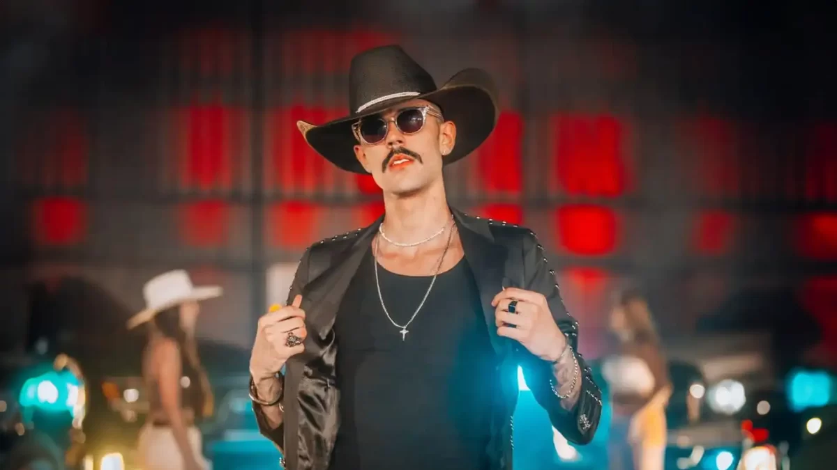 Luan Pereira, de óculos escuros e em foto posada abrindo o casaco