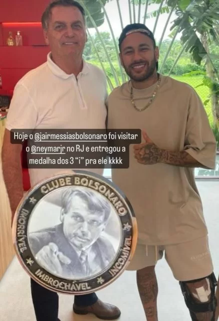 Jair Bolsonaro de camisa polo branca abraça Neymar e mostra medalha 