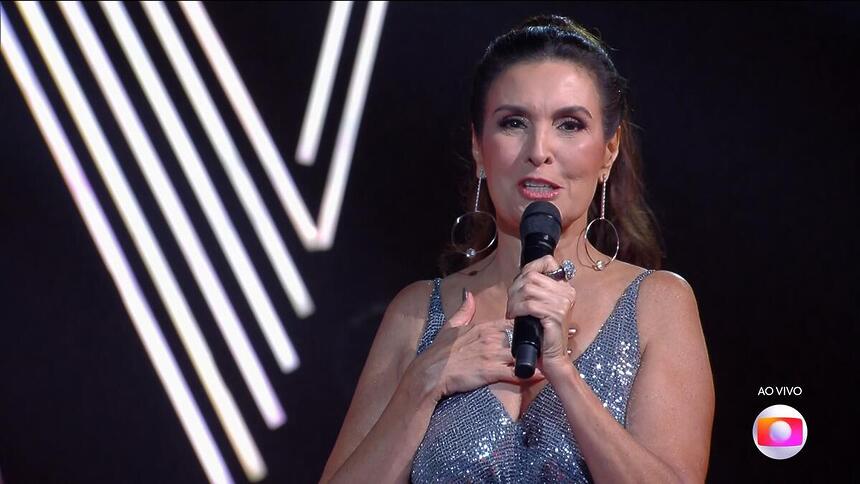 Fátima Bernardes coloca a mão no coração na final do The Voice Brasil 12