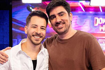 Junio Lima e Marcelo Adnet sorrindo nos bastidores do Domingão