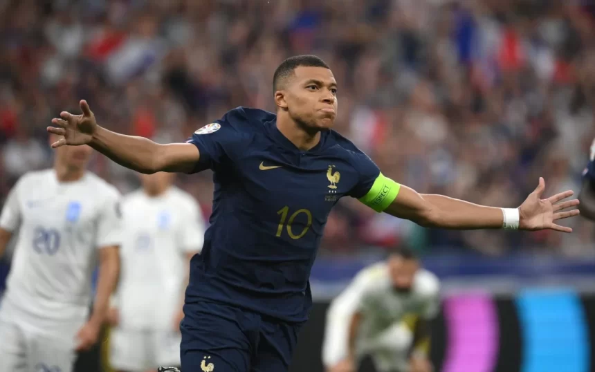 Mbappé de braços abertos com a camisa da França