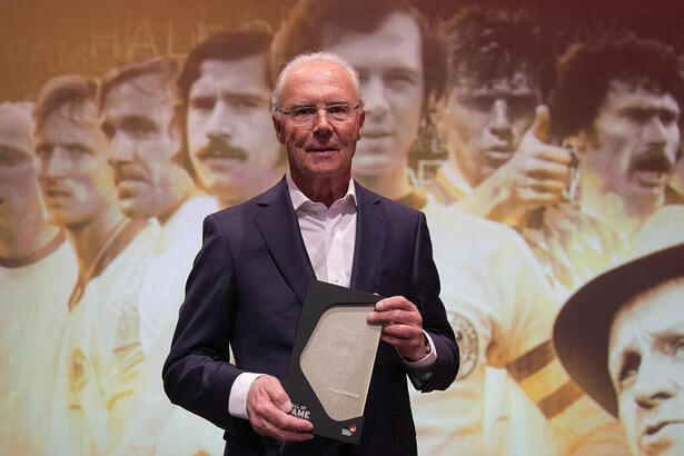 Franz Beckenbauer em foto posada segundo em troféu em mãos