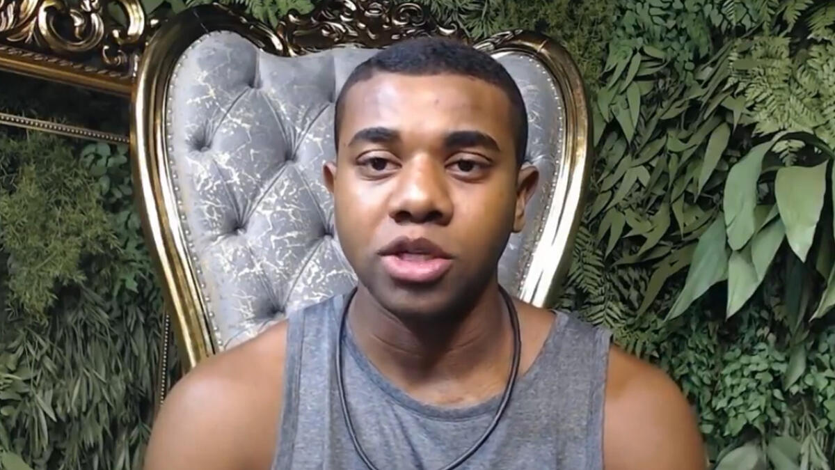 Davi de camisa regata cinza, sentado no confessionário durante Raio X