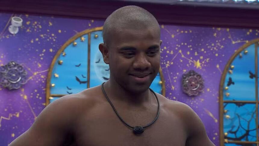 Davi sem camisa e sorrindo no quarto do BBB