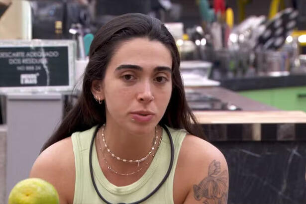 Giovanna de regata, microfone, cabelo preso, sentada na cozinha do BBB 24