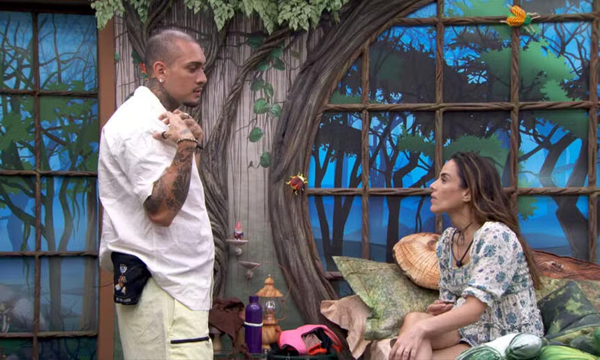 MC Bin Laden em pé, no quarto, em frente a Wanessa Camargo, conversando