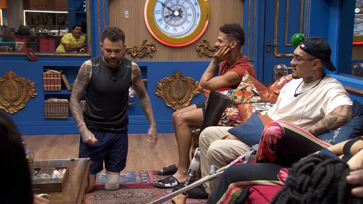 Vinicius Rodrigues de joelhos e simulando um ato sexual na sala do bbb 24