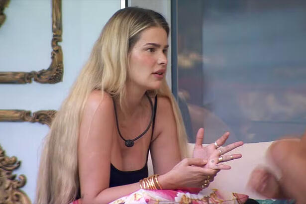 Yasmin Brunet de camisa regata preta, sentada, conversando na varanda do BBB 24