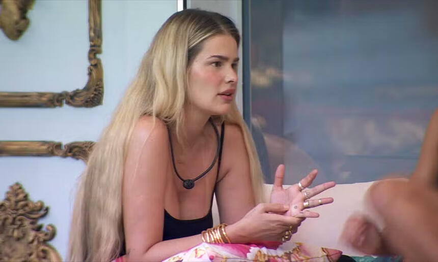 Yasmin Brunet de camisa regata preta, sentada, conversando na varanda do BBB 24