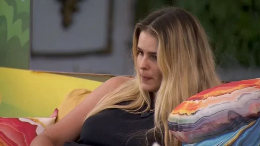 Yasmin Brunet de regata preta sentada na varanda do BBB 24 enquanto reflete sobre queridômetro