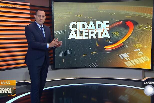 Ernani Alves apresentando o Cidade Alerta Rio e apontando para o telão