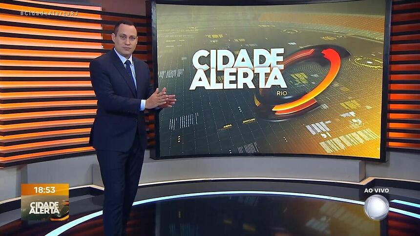 Ernani Alves apresentando o Cidade Alerta Rio e apontando para o telão