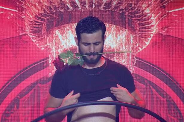 Matteus com uma rosa na boca e sensualizando na festa do BBB
