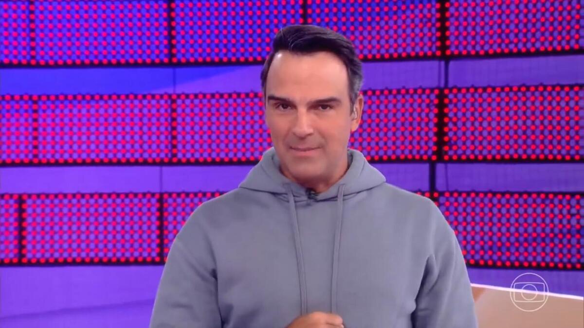 Tadeu Schmidt de moletom azul apresentando a dinâmica da semana no BBB 24