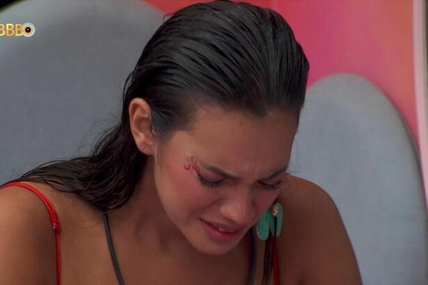 Alane com a cabeça baixa chorando no quarto fadas do BBB 24