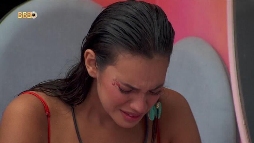 Alane com a cabeça baixa chorando no quarto fadas do BBB 24