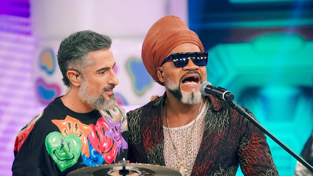 Marcos Mion abraça Carlinhos Brown no centro do palco do Caldeirão com Mion