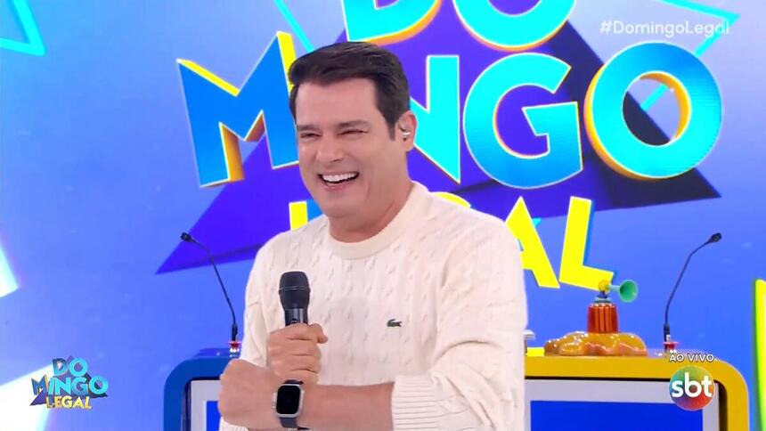 Celso Portiolli sorrindo enquanto apresenta o Domingo Legal