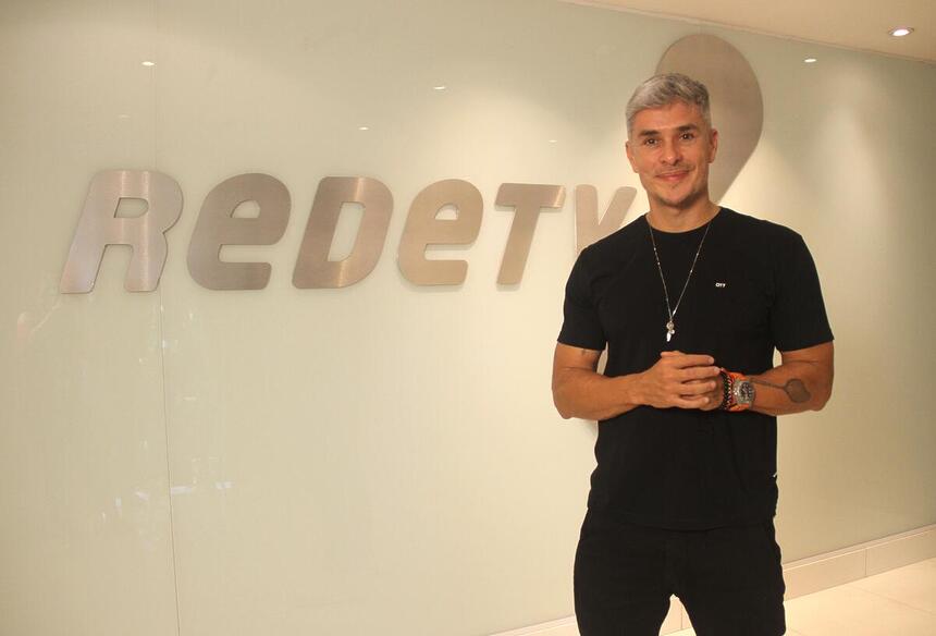 Ivan Moré na frente do logo da RedeTV!