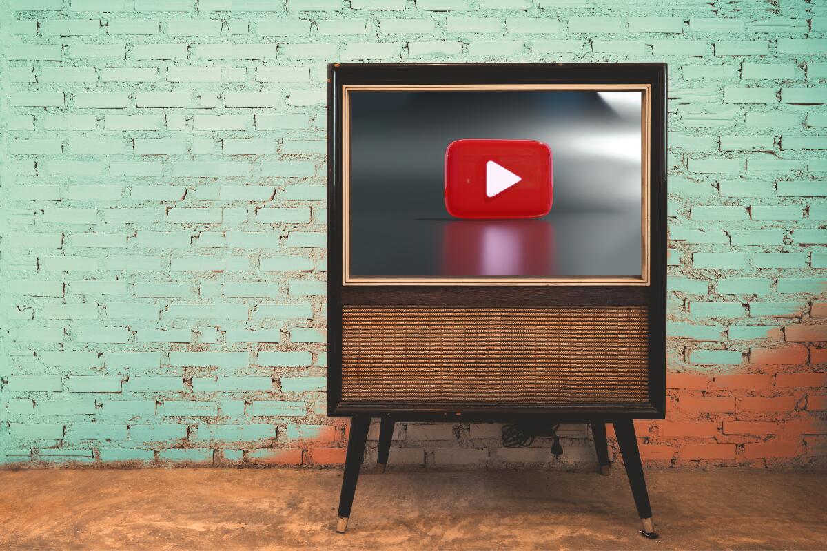 Televisão à frente de uma parede verde com o logo do Youtube