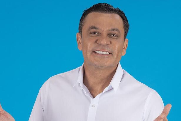 Frank Aguiar com os braços abertos e sorrindo em apresentação da TV Aparecida