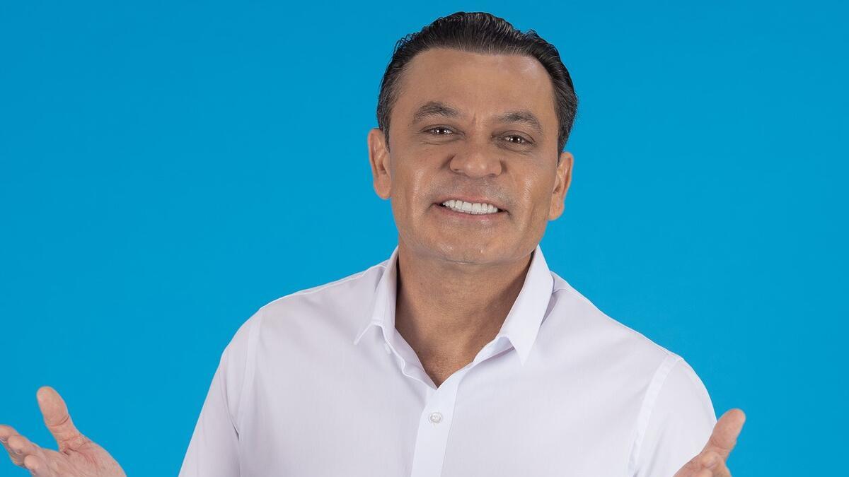 Frank Aguiar com os braços abertos e sorrindo em apresentação da TV Aparecida