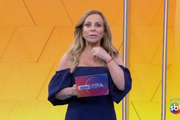 Christina Rocha à frente do telão amarelo do Tá na Hora