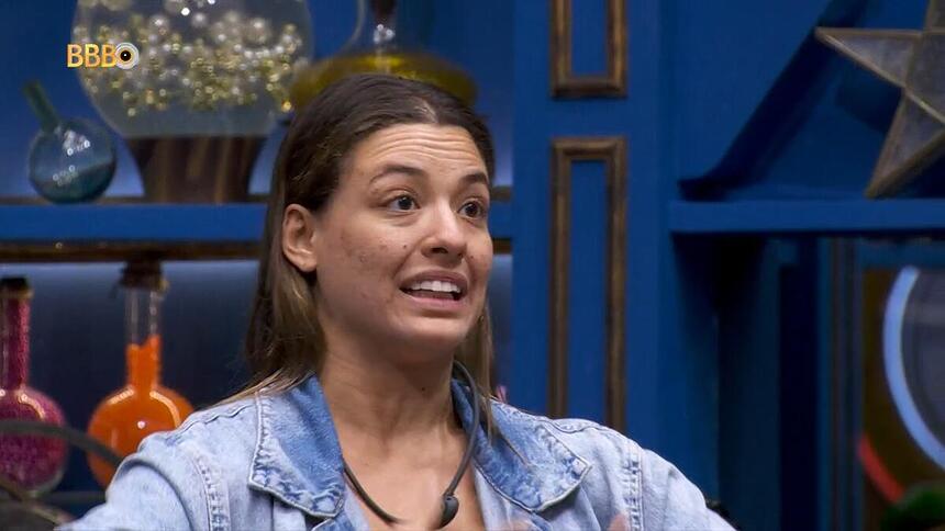 Beatriz faz gestos com as mãos como que tem fogo ao pedir votos na sala do BBB 24