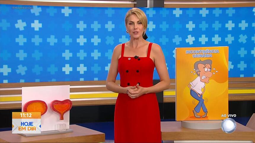 Ana Hickmann de vestido vermelho, sorrindo, no cenário do Hoje em Dia da Record