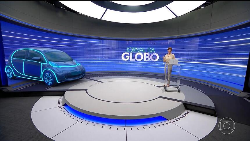 Renata Lo Prete ao lado do carro projetado no mega telão do novo cenário do Jornal da Globo