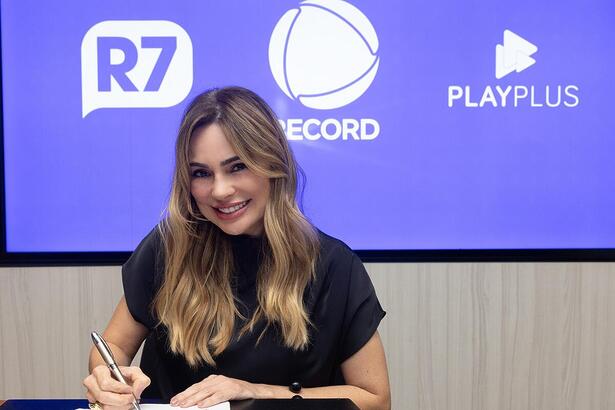 Rachel Sheherazade usa blusa preta e está sorrindo ao assinar contrato com a Record