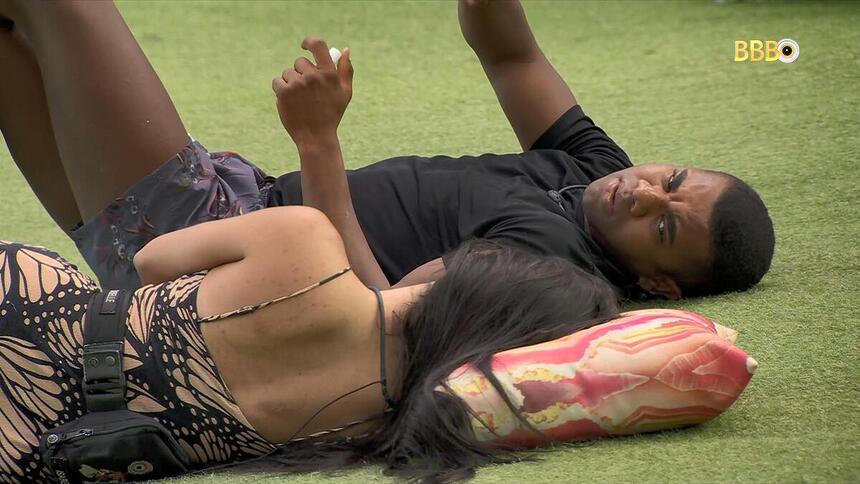 Davi e Isabelle deitados jardim e conversando no BBB 24