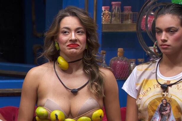 Beatriz com o top de cascas de laranja ao lado de Alane no sofá do BBB 24