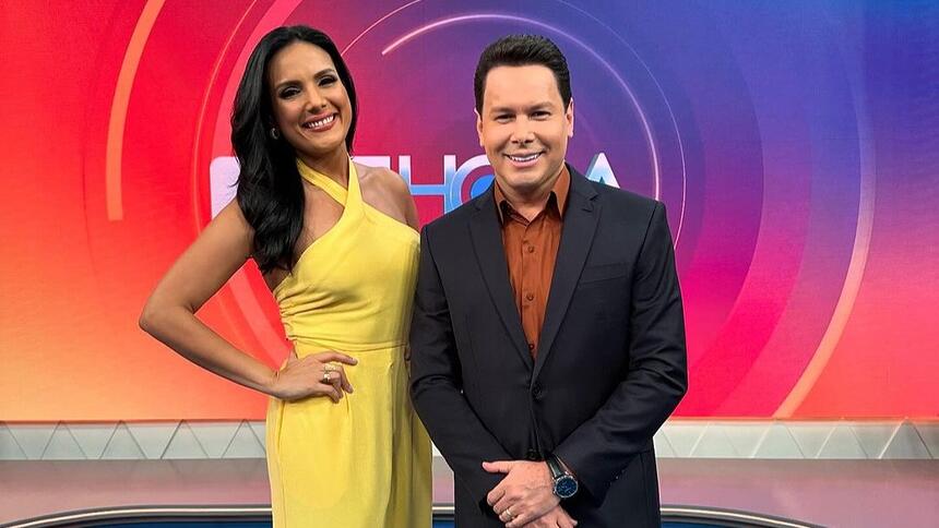 Márcia Dantas de vestido amarelo ao lado de Marcão do Povo no cenário do Tá na Hora