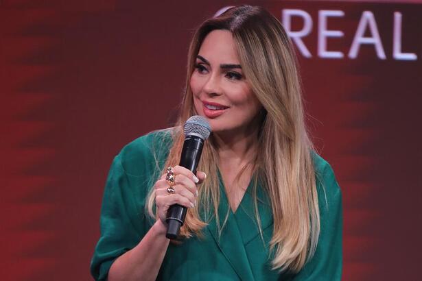 Rachel Sheherazade segura o microfone da coletiva de imprensa de A Grande Conquista 2