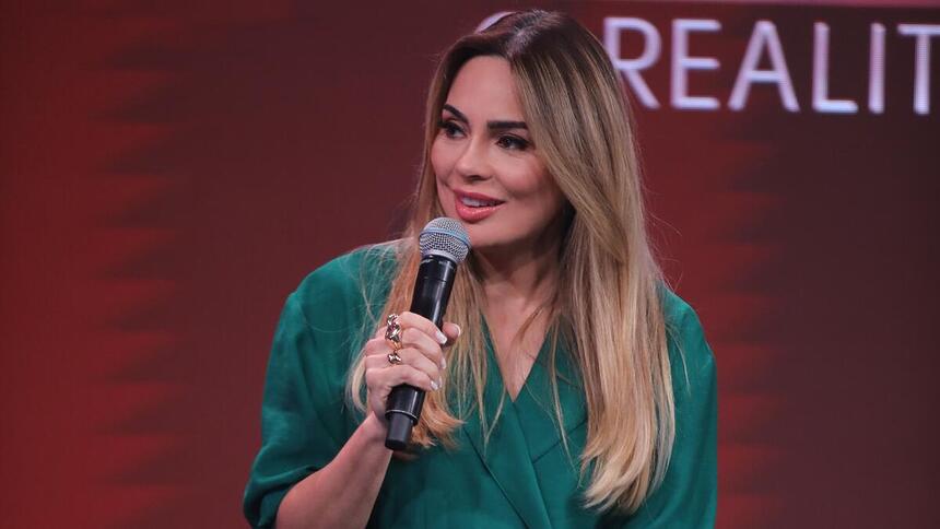 Rachel Sheherazade segura o microfone da coletiva de imprensa de A Grande Conquista 2