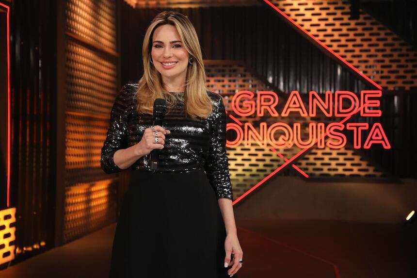 Rachel Sheherazade segura microfone na estreia do A Grande Conquista 2