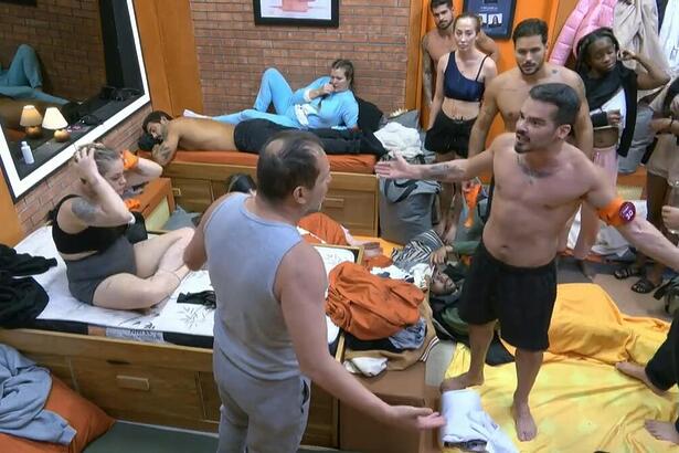 Fábio e Ricardo Costa abrem os braços em discussão na casa Laranja do A Grande Conquista 2