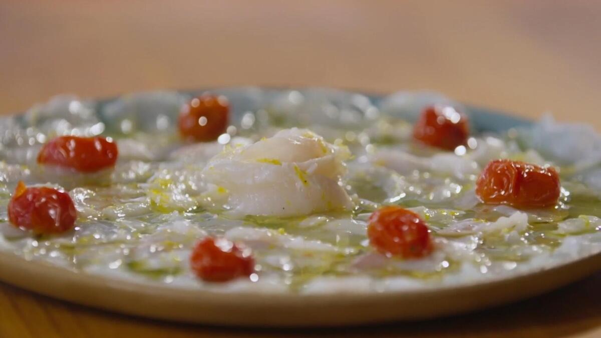 Carpaccio de namorado com tomate-cereja confitado no prato do É de Casa
