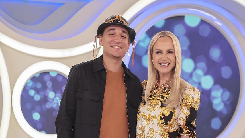 joão Gomes ao lado de Eliana sorrindo no cenário do SBT