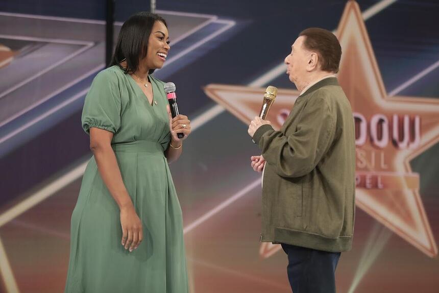 Elaien Martins sorrindo em frente a Raul Gil no palco do SBT