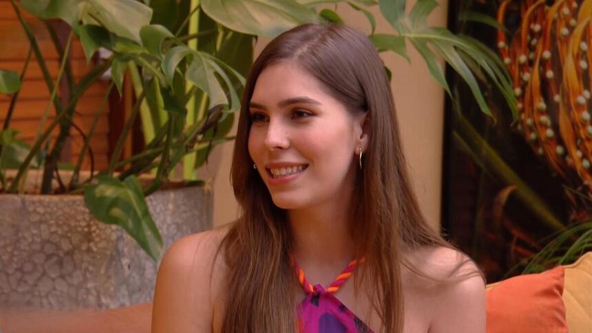 Gabriela Medeiros sorrindo no sofá do É de Casa