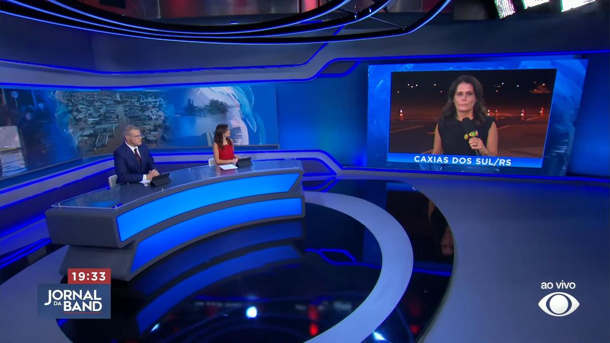 Adriana Araújo no telão do Jornal da Band com apresentadores no estúdio