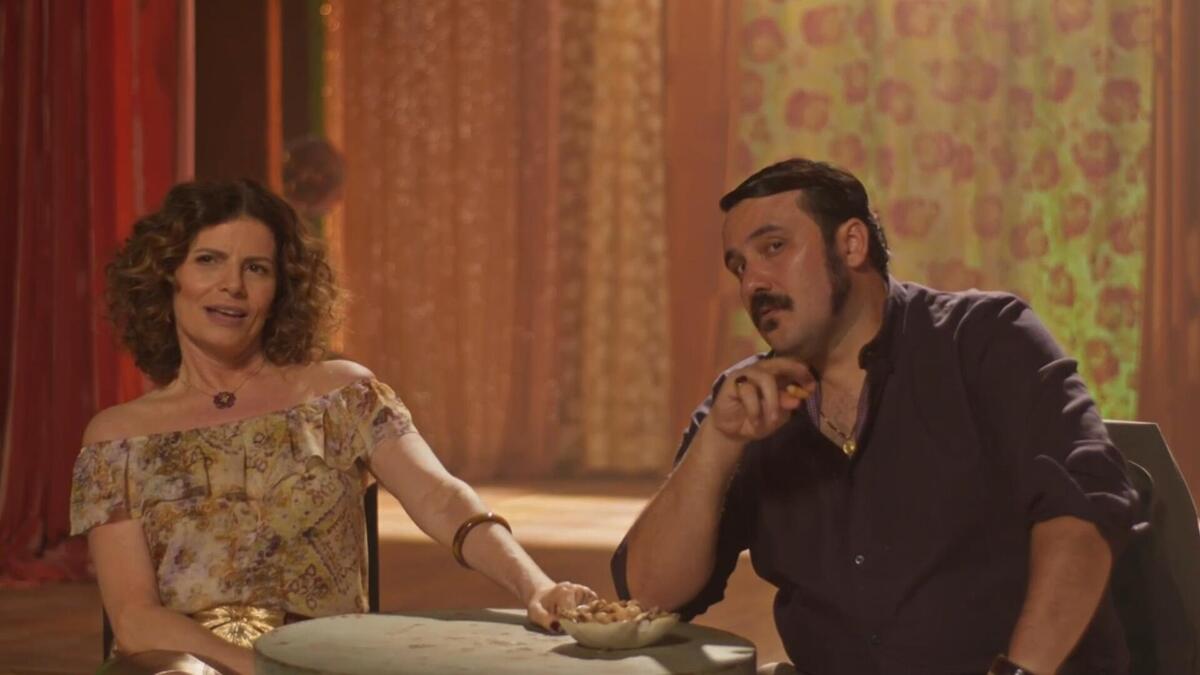 Deodora e Vespertino sentados no cabaré em cena da novela No Rancho Fundo da TV Globo